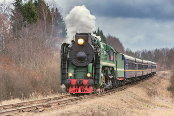 Fototapeta na wymiar Steam train moves at autumn day time.