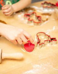 Young lady helping little boy to make gingerbread shapes. Getting ready for Christmas.