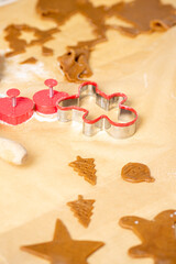 Gingear bread shapes and cookies on baking paper. Getting ready for Christmas.