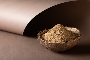 Organic brown palm or coconut sugar on brown paper background.