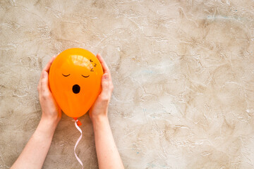 Sleepiness face on balloon - tiredness mood background. Top view, copy space