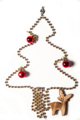 Top view on christmas tree shape made of golden beads decorated with red new year balls and wooden...
