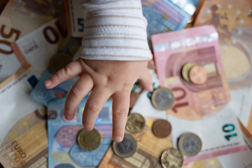 Kindergeld - Kind hält Hand über viel Bargeld