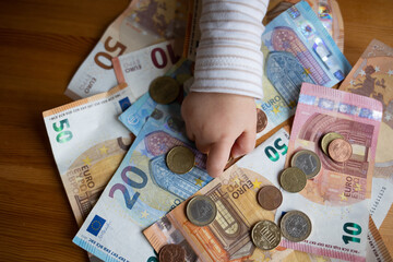 Kindergeld - Kind zeigt auf Bargeld