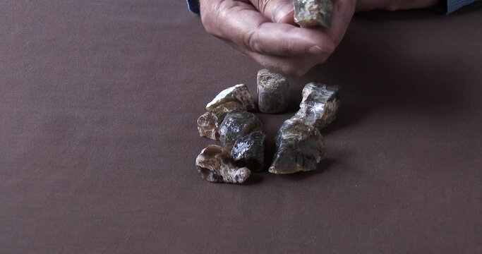 A gemologist inspecting a parcel of rough and rare African Cat's Eye Opal, close up