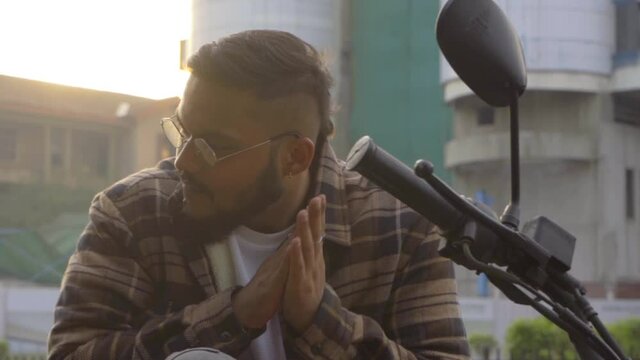 gangster looking man nose piercing seating on the bike in style rubbing hands cool style  India Mumbai rapper the unknown