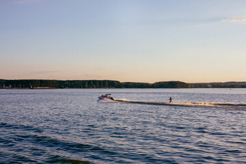 Water skiing on lake behind a boat.