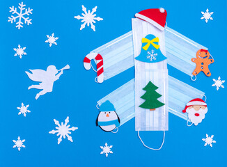 Creative Christmas tree made of medical masks, decorated with New Year's toys, white angel and...