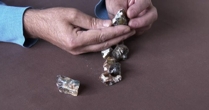 A Gemstone cutter selecting rare African Cat's Eye Opal from a parcel of rough