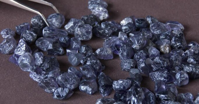 A gemologist examining and sorting rare Ilolite gems, close up