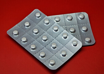 Blister packs of pills on red background 