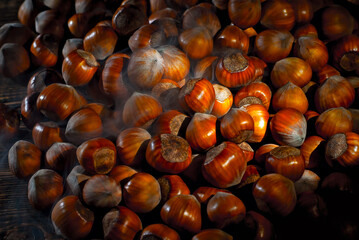 Hazelnuts on a pile close up. Texture of nuts. Contrasting dramatic light as an artistic effect.
