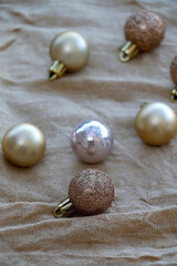Gold Christmas baubles on beige fabric. Selective focus. 