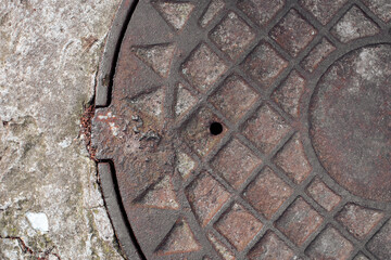 Old sewer hatch. Rusty iron sewer cover