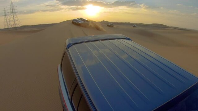 Desert safari off road, cockpit view from cabin or car, view to sunset. Jeep or SUV or 4x4 vehicle rides on desert dune barkhan or sand-dune
