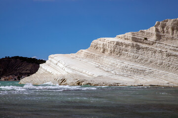 Fototapeta premium View of Rocks and sand beach in front of the white limestone cliffs of the Scala dei Turchi in Realmonte, Sicily, Italy