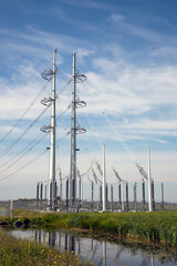 Transformer substation with electric towers (pylons) and equipment on blue sky background