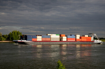 Inlandshipping container vessel transportation containers over the river in the Netherlands Waal...