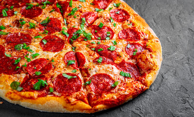 Pepperoni Pizza with Mozzarella cheese, salami, Tomato sauce, pepper, Spices. Italian pizza on Dark grey black slate background