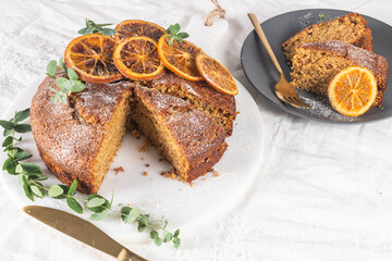 Christmas orange and spice cake. Decorated with dried oranges on kitchen countertop
