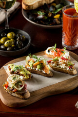 Brushetta bread sandwich snack authentic traditional spanish tapas on wooden plate at the restaurant
