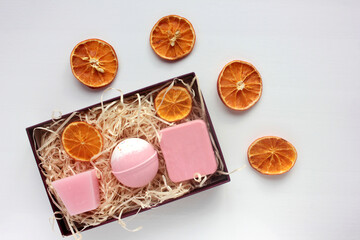 Spa gift basket with set of organic skin care products. Pink candle, bath bomb and handmade rose soap bar in gift box on white background. Christmas, Valentine`s day, Mother`s day or birthday present