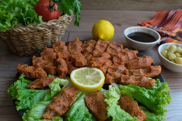 Turkish raw meatballs. Top view of lettuce, tomato, pickle and lemon, pomegranate syrup, Turkish cig kofte