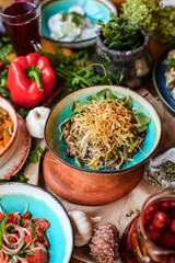Muslim Ramadan iftar family dinner. Flat-lay of people feasting over table with Middle East food. Dates, dolma, kebab, flatbread, pide, borek, sweet, salad, top view. Ramazan fasting Turkish cuisine.