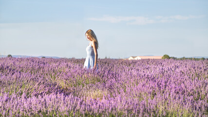 Jeune fille blonde dans le champ de lavandes en Provence en été, France