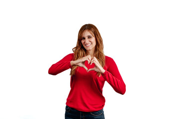 Obraz na płótnie Canvas Beautiful young woman in a red sweater, making the gesture of a heart with her hands, isolated on a white background.