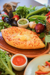 Muslim Ramadan iftar family dinner. Flat-lay of people feasting over table with Middle East food. Dates, dolma, kebab, flatbread, pide, borek, sweet, salad, top view. Ramazan fasting Turkish cuisine.