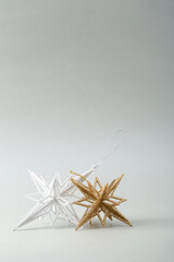 Fototapeta na wymiar White and golden Christmas stars o gray surface, copy space