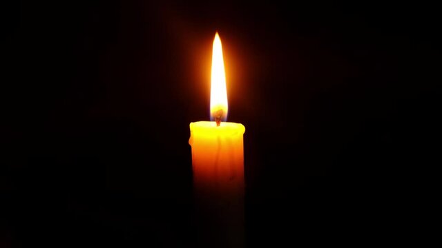 burning candle in the dark, a symbol of sorrow for the dead
