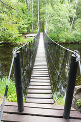 Fototapeta na wymiar hinged pedestrian bridge in the Park of waterfalls in Ruskeala in Karelia