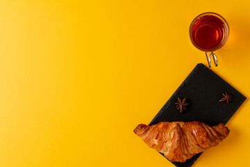 Desayuno con croissant en fondo amarillo, concepto banner para paginas web