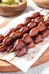 Grilled chicken hearts on a skewer close-up.