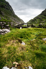 Fototapeta na wymiar Scenic view of Gap of Dunloe, County Kerry, Ireland.. The River Loe and narrow mountain pass road wind through the steep valley, nestled in the Macgillycuddy's Reeks mountains. The Ring of Kerry Route