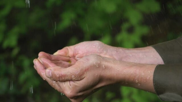 stream of fresh clean water pouring into human hands, drought land on the background. dry farmland, lack of water. Clean water splashing on hands of the poor rural man. environment and ecology