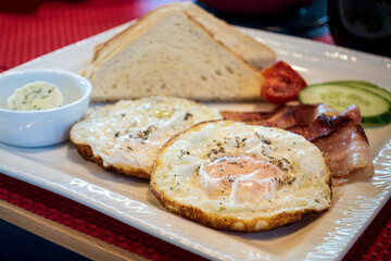 Grilled toasts served with beans, scrambled eggs and sausage for an English breakfast