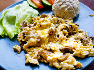 Omelet cooked with tomatoes and chives prepared with fresh lettuce as side dishes for a healthy vegetarian breakfast ready to be served