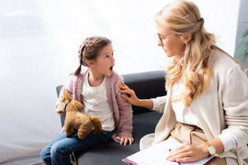 little girl with toy screaming while visiting psychologist, stock image