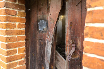 Old wooden doors in a destroyed building and a hole in them