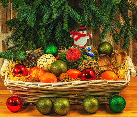
Toys for the tree, fruits in a wicker basket. Branches from the tree hang from above. A gift for the New Year.