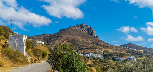 Road leading up to Mount Exomvourgo on the island of Tinos, Cyclades, Greece with houses and churches