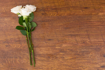 Bunch of white roses lying on wooden background