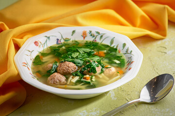 Italian wedding soup. Soup with meatballs and vegetables. Vegetable soup with chicken and beans. Side view, close-up, menu