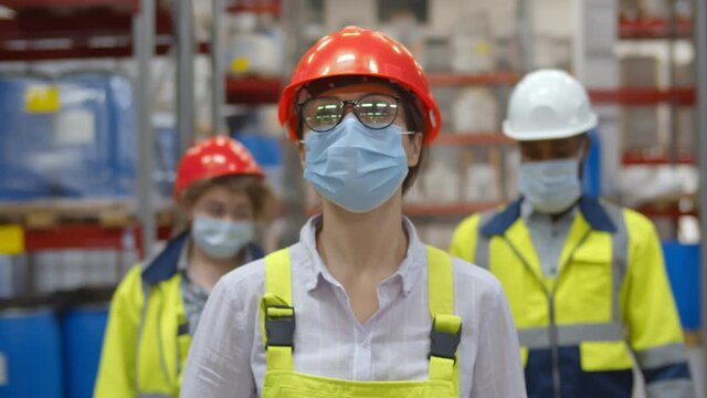 Group warehouse workers wearing protective mask working together at warehouse