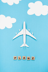 top view of airplane model and cubes with word plane on blue sky 