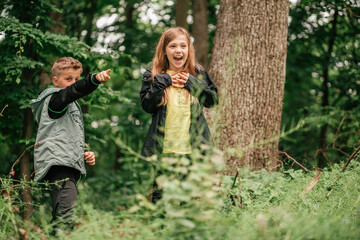 Happy little friends walking and having fun in spring forest