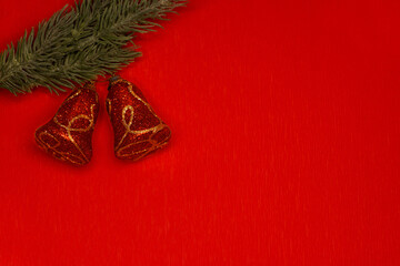 Christmas bells on fir isolated on red background